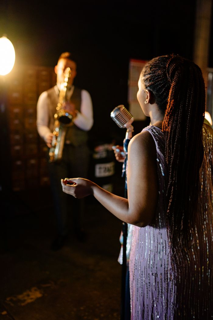 Singer and saxophonist performing on stage in an elegant nightclub setting.